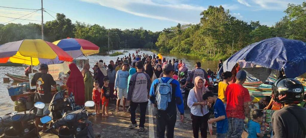 Petugas membantu masyarakat melintasi banjir menggunakan perahu karet di Kabupaten Murung Raya, Kalimantan Tengah, Senin (23/5/2022). Setidaknya 19 desa dari enam kecamatan di Murung Raya terdampak banjir.