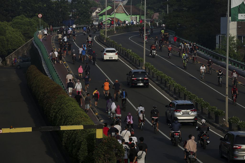 Pengendara sepeda melintasi jalan layang di kawasan Bintaro, Tangerang Selatan, Minggu (21/6/2020) pagi. Masa transisi pembatasan sosial berskala besar (PSBB) membuat warga mulai melakukan kegiatan olah raga di luar ruangan.