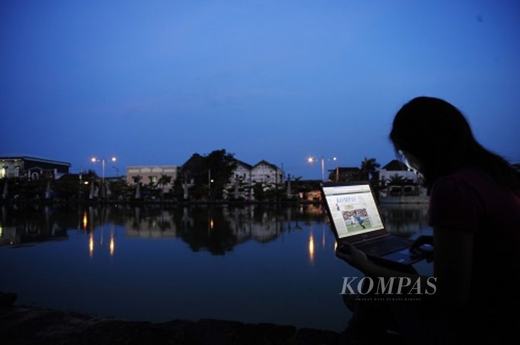 Era digital juga membawa perubahan pada koran cetak ke lembar digital yang dapat diakes melalui internet seperti Leonita (24) yang membuka <i>e-paper </i>harian <i>Kompas </i>saat santai di Polder Tawang, Kota Semarang, Jawa Tengah, Minggu (27/6/2010).