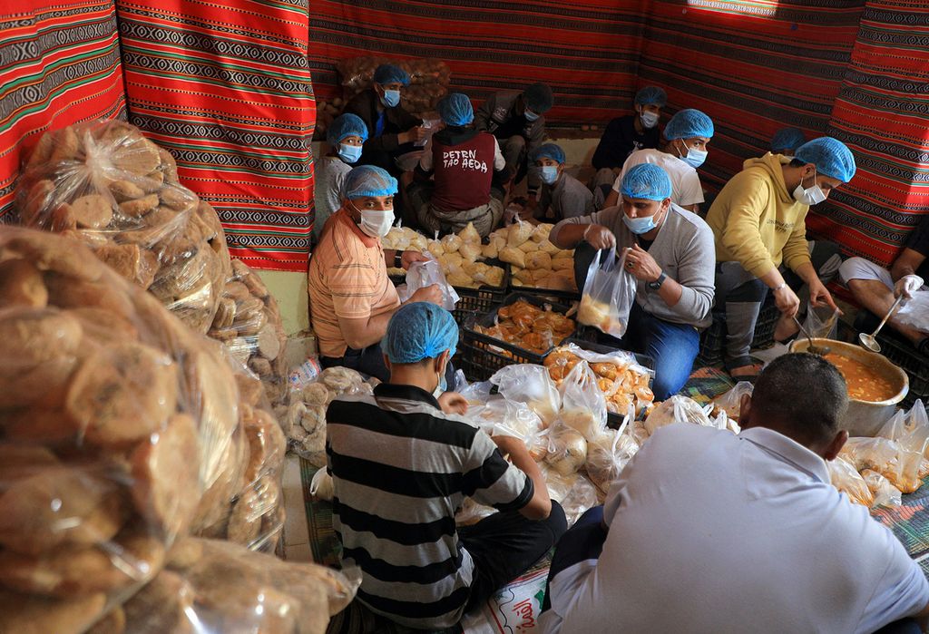 Relawan menyiapkan makanan untuk dibagikan secara gratis untuk berbuka puasa di ibu kota Sanaa, Yaman, selama bulan suci Ramadhan, Senin (4/4/2022).