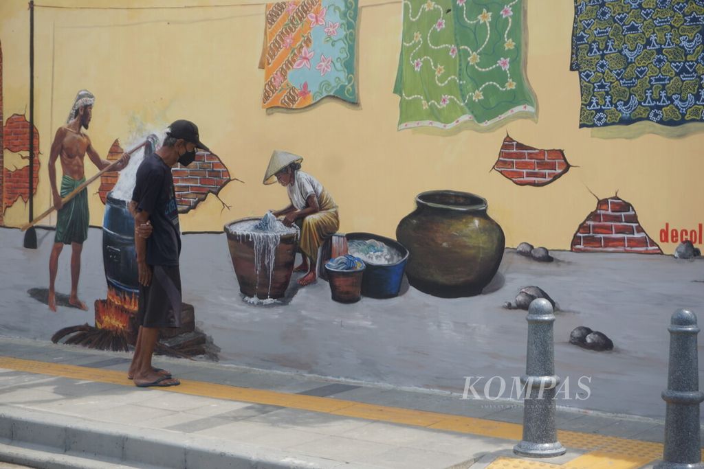Warga melihat lukisan di Kota Lama Banyumas di Jawa Tengah, Selasa (16/1/2024).