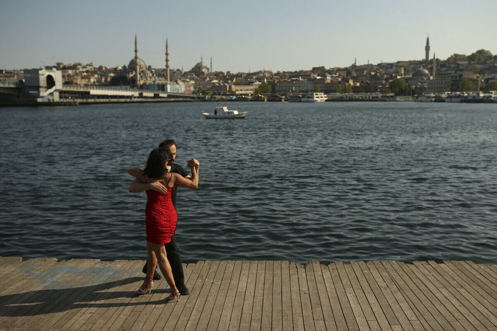 Sepasang kekasih menari di dekat Tanduk Emas di Selat Bosphorus yang memisahkan Eropa dan Asia, di Istanbul, Jumat (14/5/2021). 