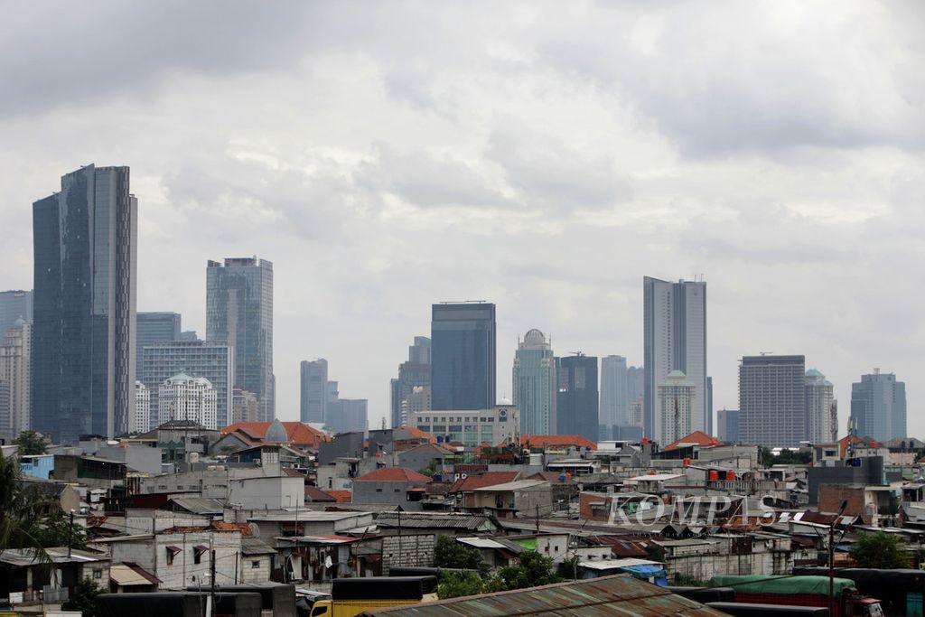 Perkampungan padat penduduk dengan latar belakang gedung bertingkat di Jakarta, Jumat (23/12/2022). Pemerintah akan melanjutkan program perlindungan sosial untuk mendorong tingkat kemiskinan pada 2023 menurun di kisaran 7,5-8,5 persen, tingkat pengangguran terbuka 5,3-6,0 persen, dan perbaikan ketimpangan (rasio gini) menjadi 0,375-0,378. 