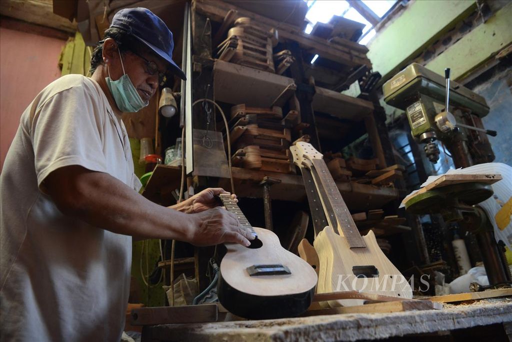 Pekerja mengamplas permukaan gitar ukulele di industri kreatif Zakk Zakk Guitar, Kelurahan Patehan, Kecamatan Kraton, Yogyakarta, Kamis (8/8/2019). Sasaran konsumen gitar berbahan kayu tripleks itu adalah anak-anak serta gitaris yang suka bepergian.