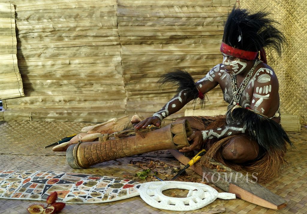 Pengukir suku Kamoro memperlihatkan tifa di bengkel kerja dan galeri ukiran Yayasan Maramowe di Kampung Nawaripi, Distrik Wania, Kabupaten Mimika, Jumat (18/3/2022).  