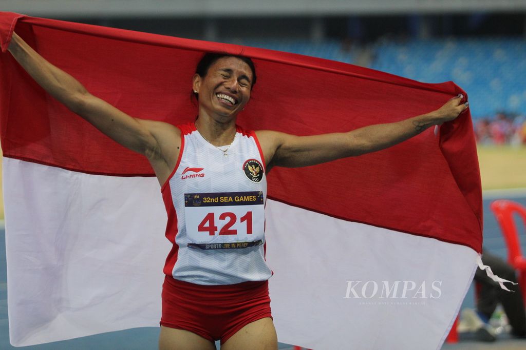Maria Natalia Londa berlari sambil memegang bendera Indonesia usai memenangi pertandingan lompat jauh putri di ajang final SEA Games 2023 di Morodok Techo National Stadium, Rabu (10/5/2023). Ia mendapatkan medali emas dengan catatan lompat 6,28 meter.