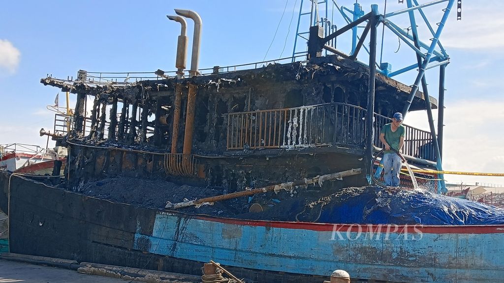 Salah satu pekerja sedang membersihkan kapal yang terbakar, Kamis (21/3/2024). Dua kapal ikan yang bersandar di Pelabuhan Muara Baru, Penjaringan, Jakarta Utara, terbakar pada Rabu (20/3/2024) sore.