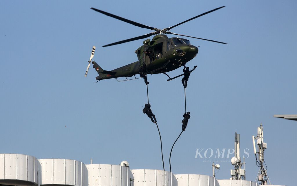 Helikopter TNI menurunkan personel Komando Operasi Khusus (Koopssus) dengan teknik <i>fast rooping</i> menuju atap hotel untuk melakukan infiltrasi dari udara dalam misi pembebasan sandera teroris saat latihan penanggulangan terorisme di kawasan Ancol, Jakarta Utara, Selasa (21/6/2022).