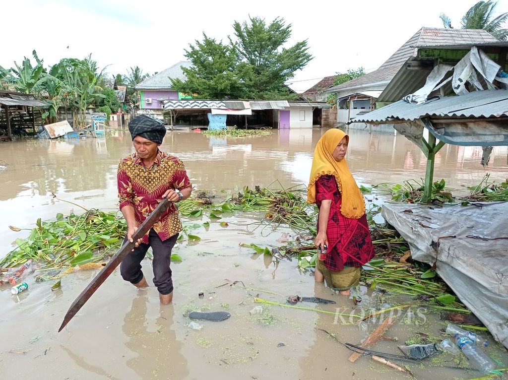 Pedagang menyelamatkan lapak dan sisa dagangan dari banjir di Kawasan Wisata Banten Lama, Kota Serang, Rabu (2/3/2022).