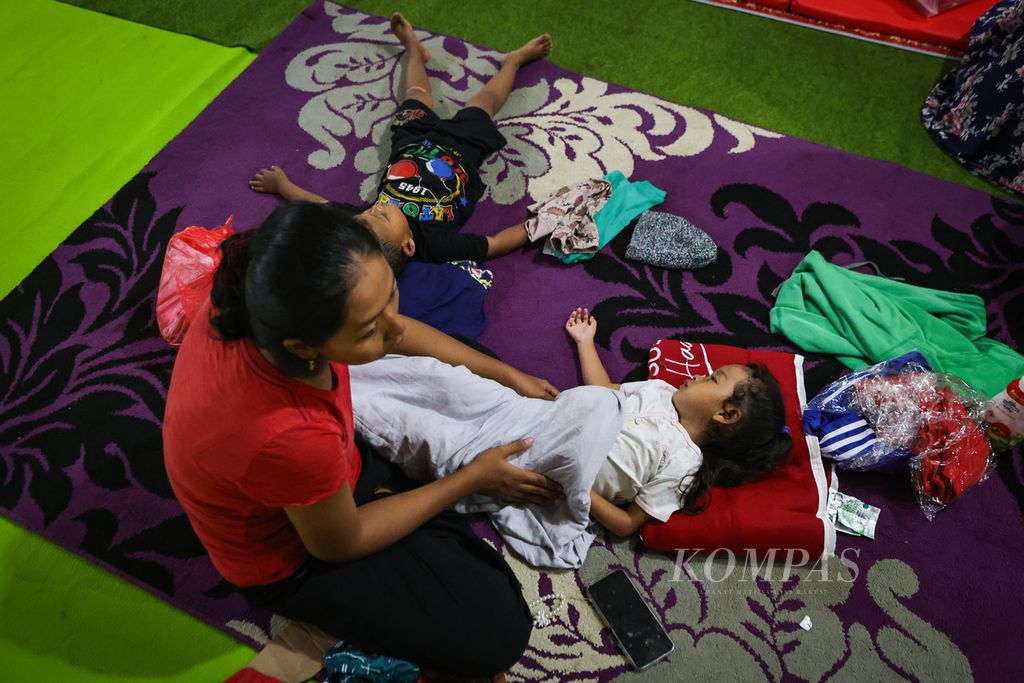 Residents affected by the explosion at the Daerah Ammunition Warehouse (Gudmurah) of Kodam Jayakarta put their children to sleep at the evacuation post in Ciangsana, Bogor Regency, West Java, on Sunday (31/3/2024).