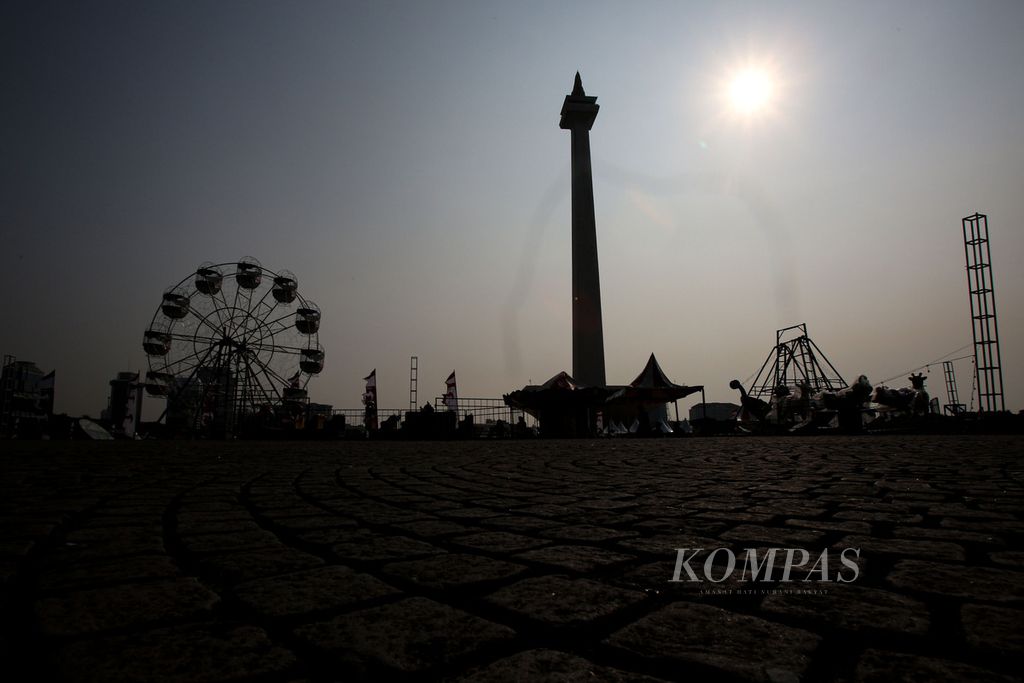 Siluet sejumlah wahana bermain yang sedang disiapkan di kawasan Monas, Jakarta, Jumat (21/6/2024).