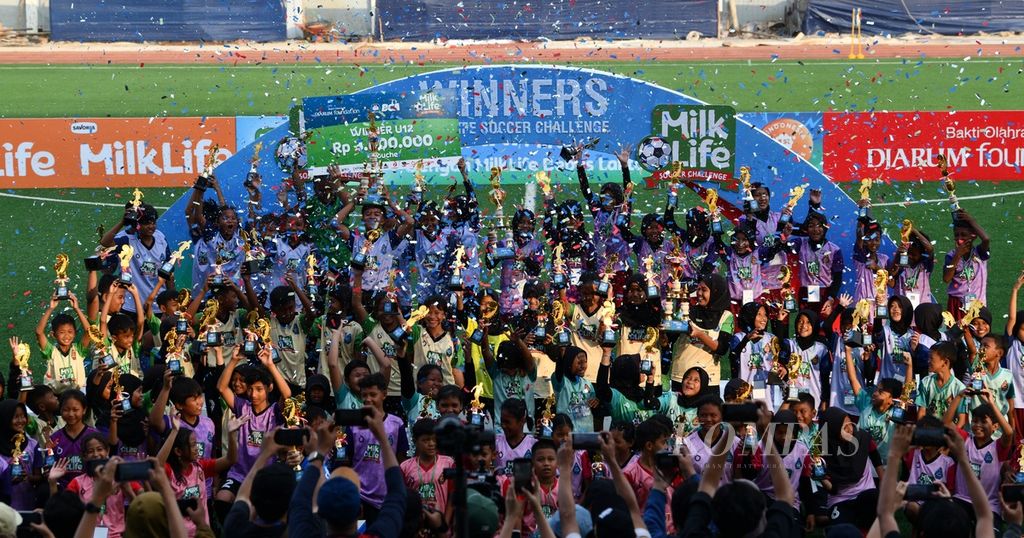 Para pemain tim juara dan semifinalis turnamen MilkLife Soccer Challenge 2023 melakukan selebrasi bersama di podium setelah pertandingan final kelompok usia U-10 dan U-12 di Stadion Supersoccer Arena, Kudus, Jawa Tengah, Minggu (17/12/2023). 