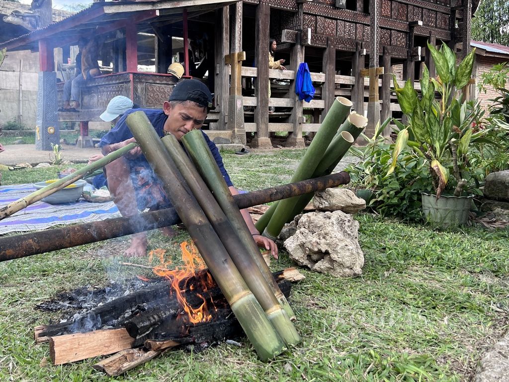 Seorang warga di Desa Kole Sawangan, Kecamatan Malimbong Balepe, Tana Toraja, Sulawesi Selatan, membakar bambu berisi aneka bahan makanan, Minggu (19/11/2023). Di Toraja, makanan ini disebut pa’piong. 