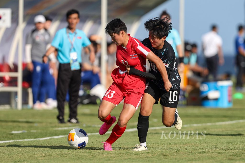 Pemain Korea Selatan, Park Ji-yu (kanan), berebut bola dengan pemain Korea Utara, Choe Yon A, pada laga Piala Asia Putri U-17 di Bali United Training Center, Gianyar, Bali, Senin (6/5/2024). Korea Utara menang dengan skor telak 7-0. 