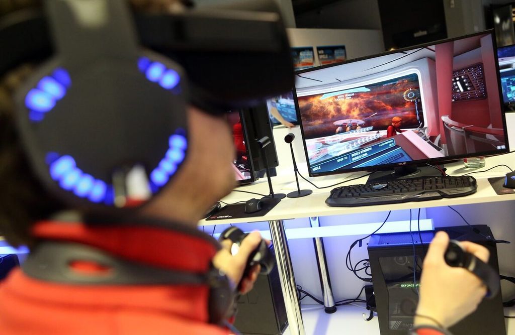Pengunjung menggunakan <i>headset virtual reality</i> dan pengendali untuk memainkan gim video Star Trek di konferensi pembuatan gim selama International Games Week di Berlin, Jerman, Rabu (26/4/2017).