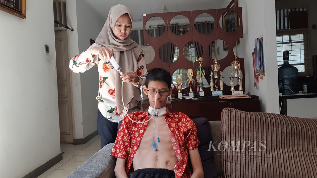 Sultan Rifat Alfatih (20) tengah makan siang dengan makanan cair yang disuntikkan ibunya melalui selang yang langsung masuk lewat hidungnya, di rumahnya di kawasan Bintaro, Ciputat Timur, Tangerang Selatan, Selasa (1/8/2023).