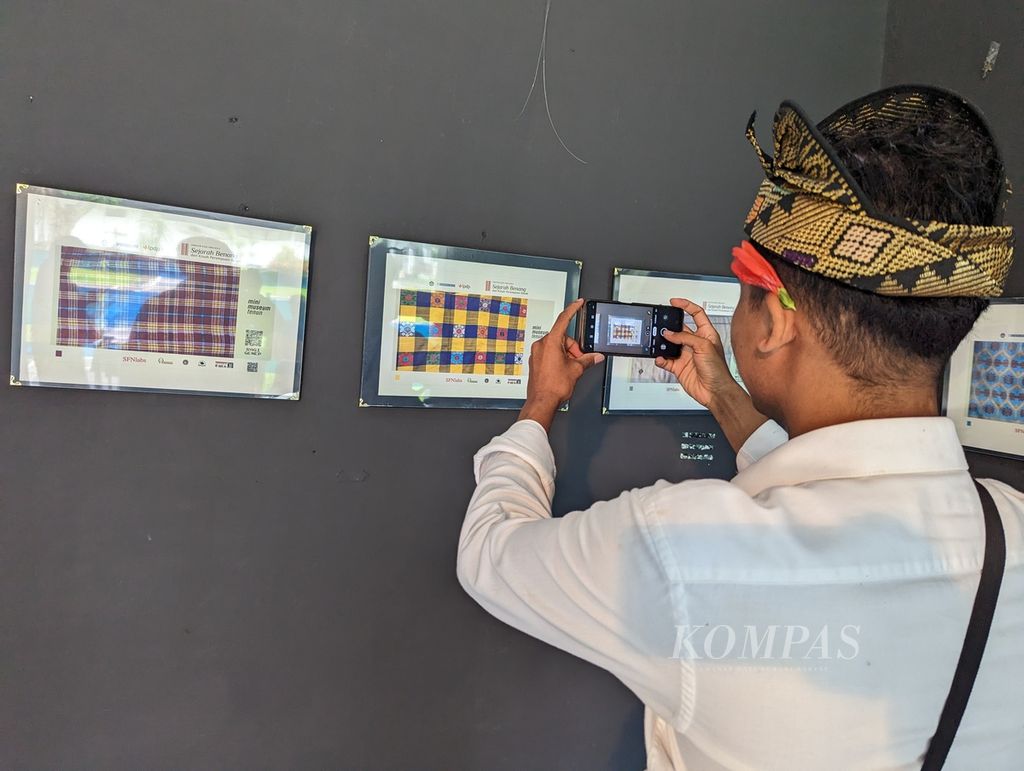 Pengunjung memindai kode batang untuk mendapatkan penjelasan lebih lengkap tentang kain tenun Sasak yang dipamerkan dalam Mini Museum Tenun Sasak di Taman Budaya NTB, Mataram, Sabtu (24/12/2022).