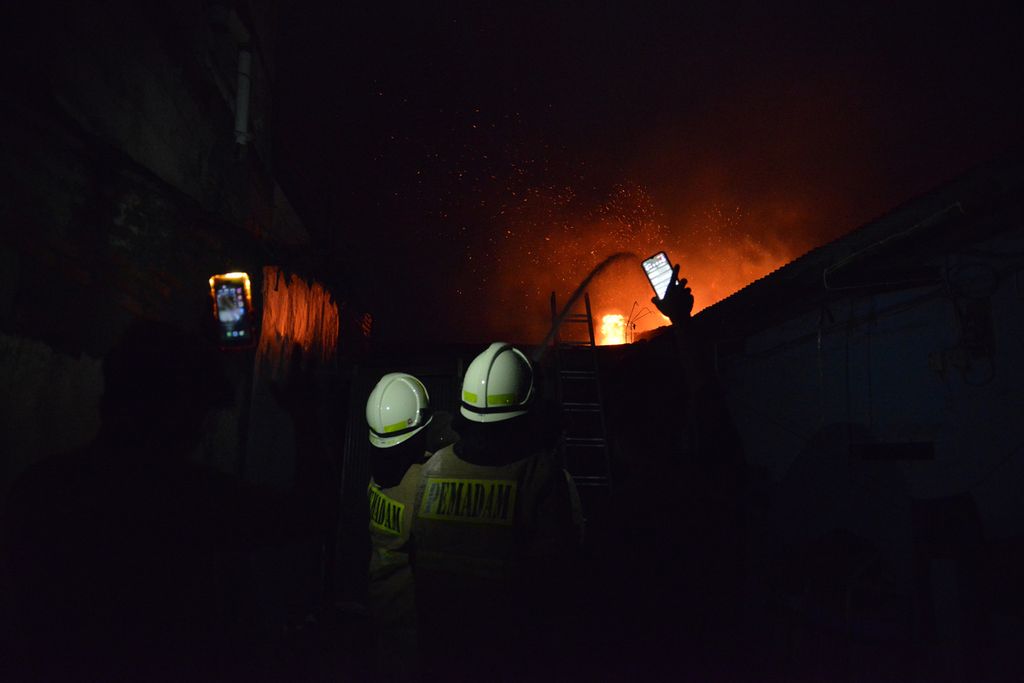 Sejumlah pemadam kebakaran memadamkan api di Jalan Tanah Merah Bawah, Kecamatan Koja, Jakarta Utara, Jumat (3/3/2023). Kebakaran ini mengakibatkan belasan orang meninggal. Belum diketahui penyebab kebakaran tersebut. 