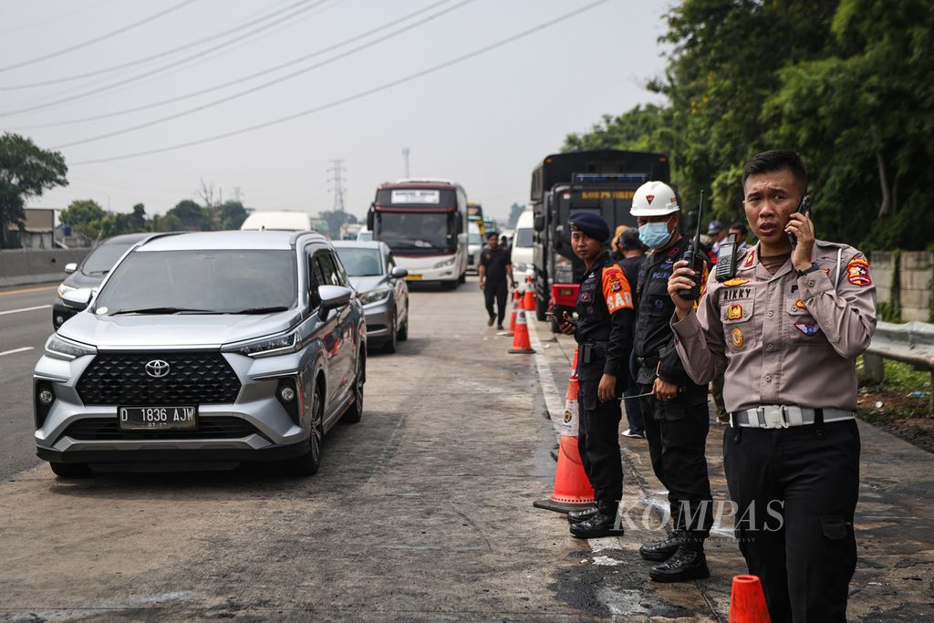 Polisi mengamankan lokasi kecelakaan di Jalan Tol Jakarta-Cikampek Kilometer 58, Karawang, Jawa Barat, Senin (8/4/2024). 