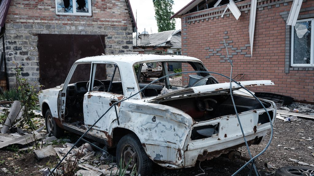 Mobil hancur terparkir di depan rumah yang juga porak poranda karena invasi Rusia ke Ukraina di Toretsk, Ukraina (16/5/2022). Invasi Rusia yang juga menyerang permukiman warga sipil menggugah nasionalisme bangsa Ukraina.