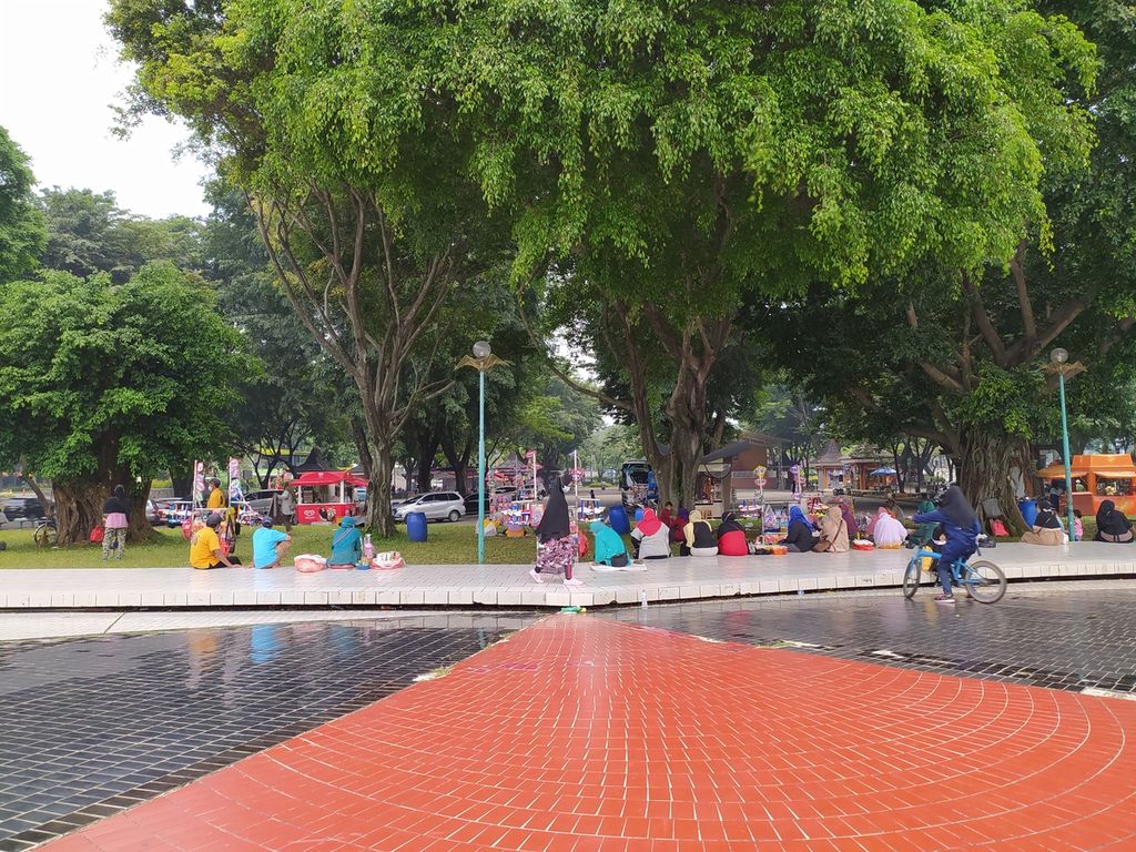 Pengunjung bersantai di bawah pepohonan di Taman Mini Indonesia Indah, Jakarta Timur, Sabtu (20/3/2021). Berlaku pembatasan pengunjung hanya 25 persen untuk memutus mata rantai penularan Covid-19.
