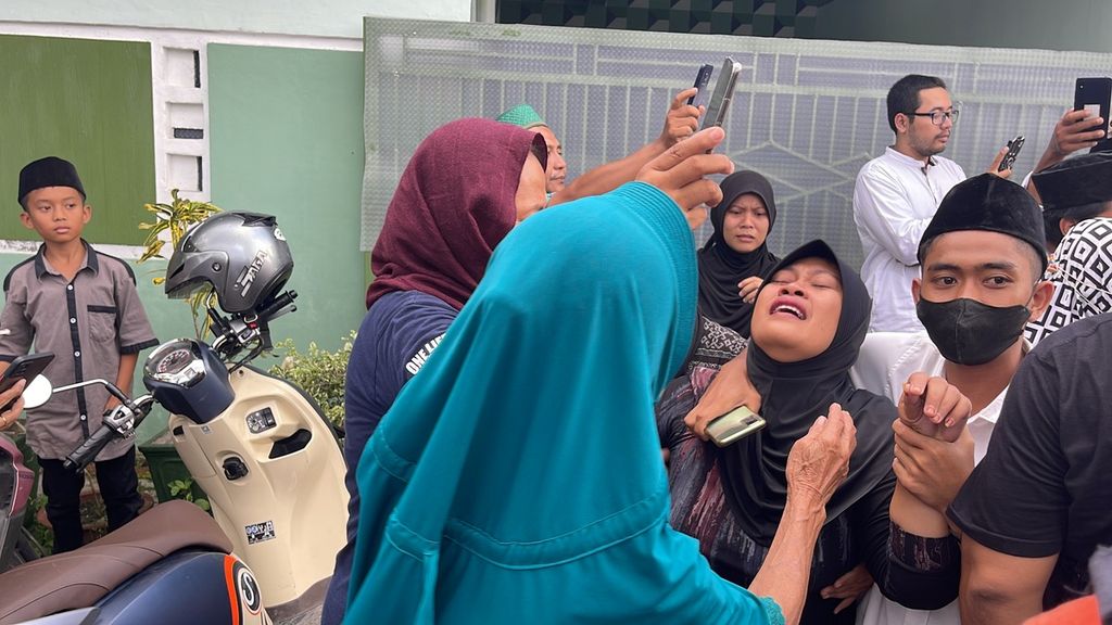 Salah satu anggota keluarga Syech Mulachela (38), pekerja migran Indonesia yang meninggal dalam kecelakaan kapal di perairan Johor, Malaysia, tidak kuasa menahan tangis saat jenazah PMI tersebut tiba di Kampung Bhineka, Desa Kopang, Kecamatan Kopang, Jumat (24/12/2021). 