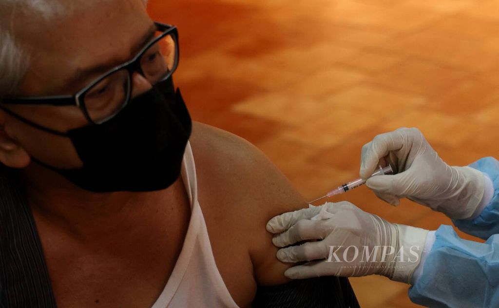 An elderly man received a second booster Covid-19 vaccine injection during a booster vaccination for retired Kompas Gramedia and senior citizens at Bentara Budaya Jakarta, in Jakarta, Wednesday (14/12/2022).