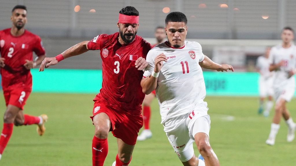 Penyerang Indonesia, Ragnar Oratmangoen (kanan), berebut bola dengan bek Bahrain, Waleed al-Hayam, pada Kualifikasi Piala Dunia 2026, Kamis (10/10/2024), di Stadion Nasional Bahrain, Riffa. Ragnar mencetak satu gol pada laga yang berakhir imbang 2-2 ini.