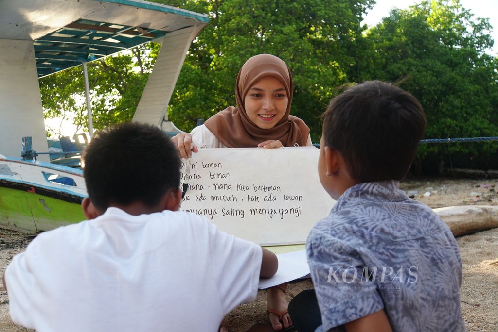 Nurfadiilah Thamrin (21) menuntun Ezhar (8) dan Al Ghazali (9) membaca, Sabtu (18/11/2023), dalam kelas informal baca-tulis yang diselenggarakan komunitas literasi Aksara Manado di Pulau Bunaken, Manado, Sulawesi Utara. 