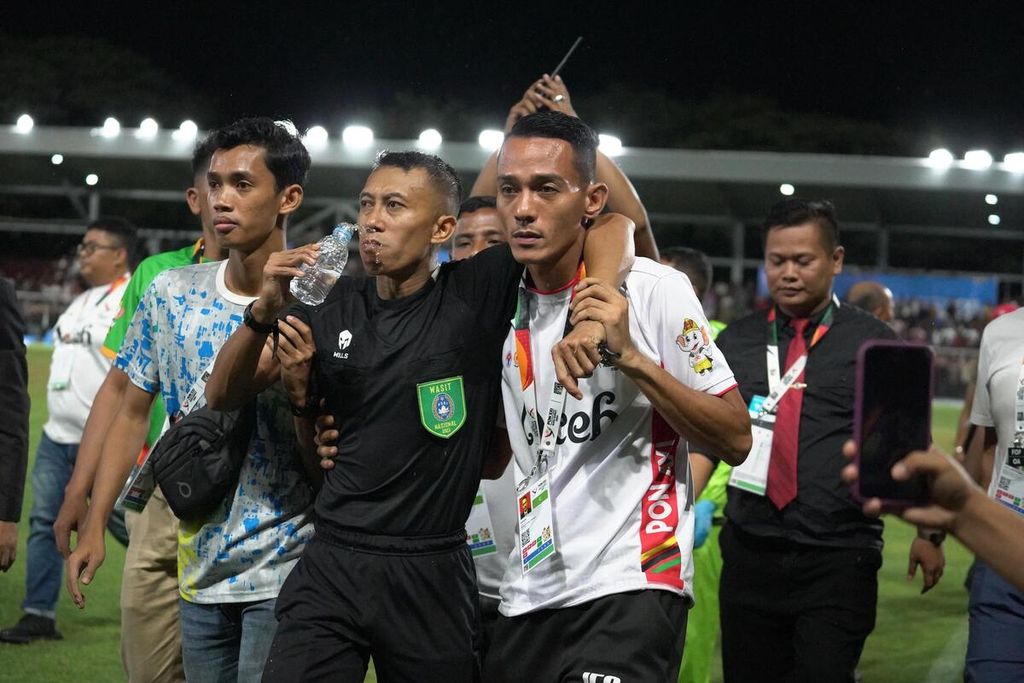 Tim medis memberikan perawatan kepada wasit yang dipukul bek Sulawesi Tengah, Muhamad Rizki Saputra, dalam laga antara tim Aceh dan Sulawesi Tengah dalam perempat final PON Aceh-Sumut 2024 di Stadion Haji Dirmurthala, Banda Aceh, Sabtu (14/9/2024) malam. Tiga kartu merah dan dua hukuman penalti diberikan kepada Sulteng yang membuat mereka memilih tidak melanjutkan pertandingan yang sejatinya berakhir seri 1-1 tersebut.