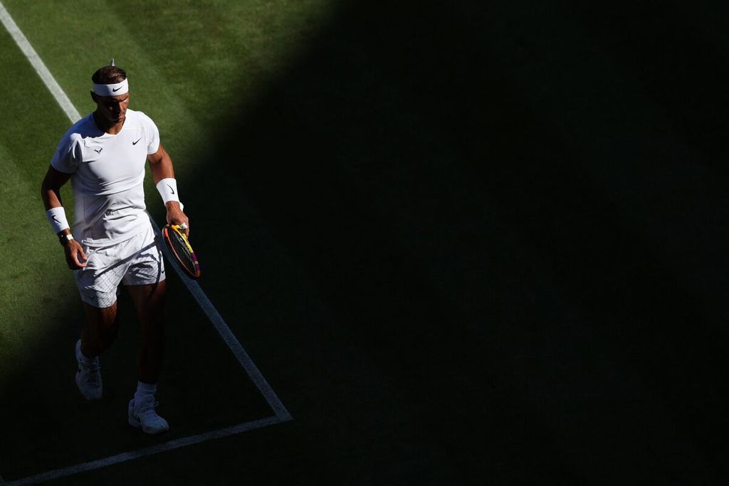 Reaksi petenis Rafael Nadal saat bertanding melawan Ricardas Berankis di babak kedua turnamen Wimbledon di All England Tennis Club, Wimbledon, Kamis (30/6/2022). Para petenis peserta turnamen Grand Slam Wimbledon menjadi waspada setelah tiga petenis unggulan tunggal putra positif Covid-19 dan mengundurkan diri dari turnamen. 