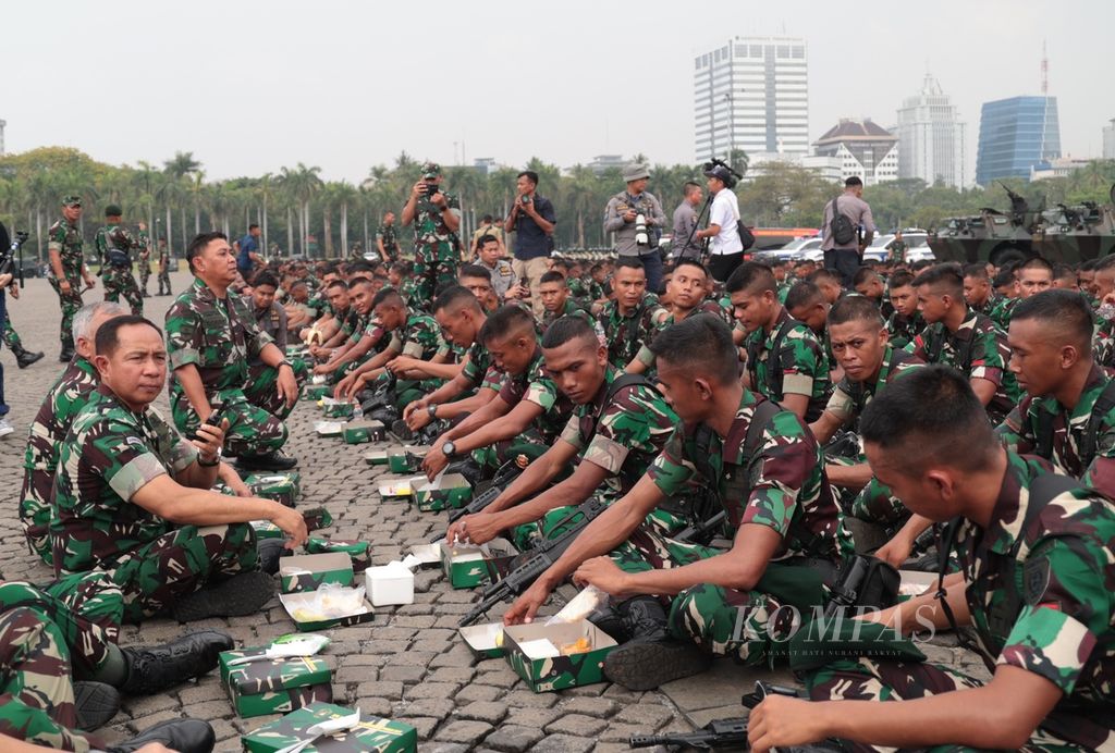 Kepala Staf TNI Angkatan Darat Jenderal Agus Subiyanto (kiri) makan bersama prajurit di sela-sela memimpin apel gelar pasukan pengamanan Pemilu 2024 di kawasan Monas, Jakarta, Rabu (8/11/2023). Sebanyak 11.000 personel TNI AD diterjunkan untuk pengamanan Pemilu 2024.
