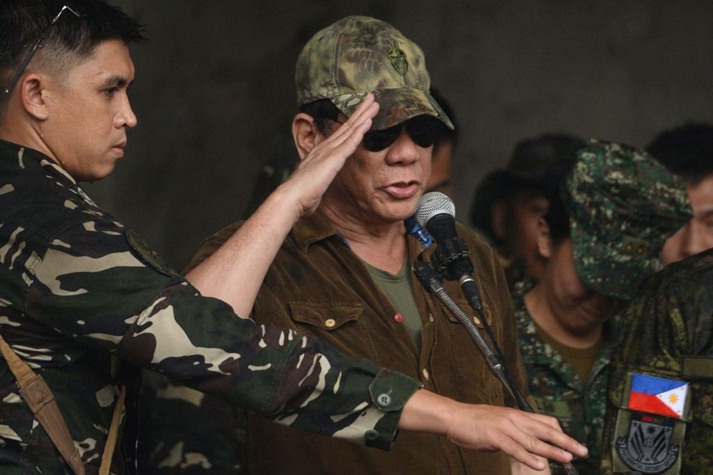 Presiden Filipina Rodrigo Duterte (tengah) memberikan tanda hormat di hadapan tentara Filipina setelah menyatakan Kota Marawi dibebaskan dari teroris, di Marawi, Filipina selatan, Selasa (17/10).