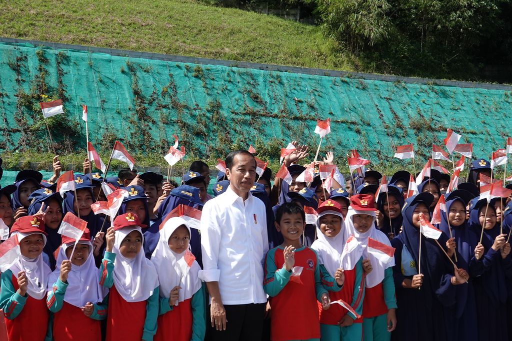 Presiden Joko Widodo berfoto dengan para siswa setelah meresmikan Jalan Tol Cileunyi-Sumedang-Dawuan (Cisumdawu) di depan terowongan <i>twin tunnel</i>, Tol Cisumdawu KM 169, Kabupaten Sumedang, Jawa Barat, pada Selasa (11/7/2023). 