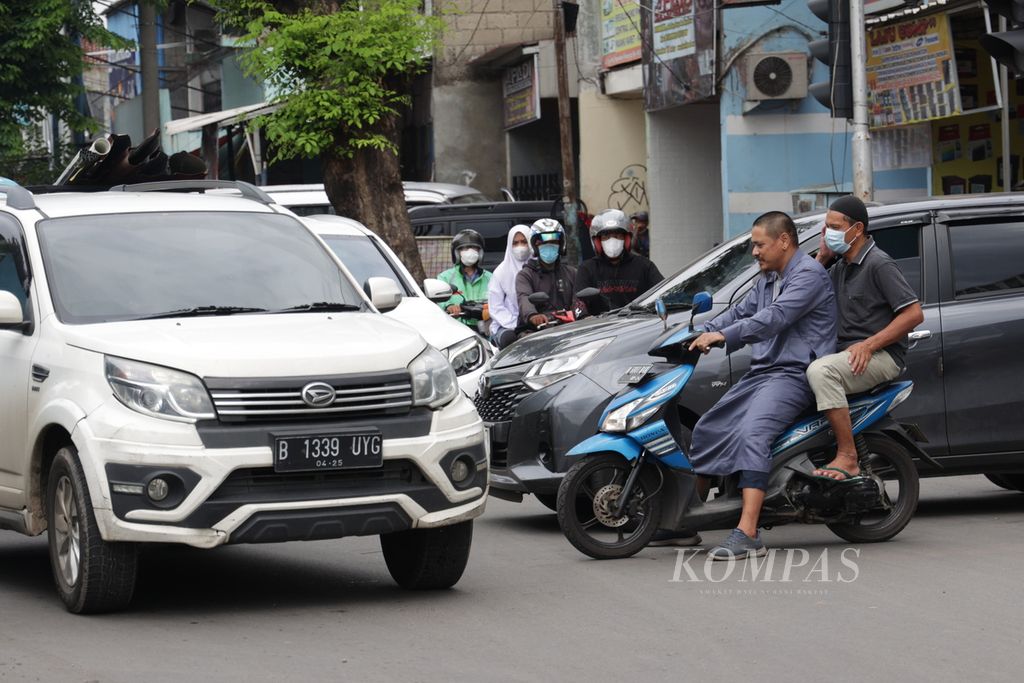 Pengguna jalan melintas di perempatan Jalan Pos Pengumben, Jakarta Barat, Jumat (3/2/2023). 