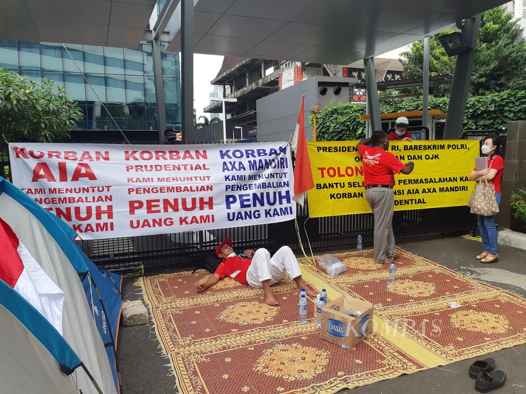 Komunitas Korban Asuransi berunjuk rasa hingga mendirikan tenda untuk bermalam di depan kantor Prudential, Jalan Sudirman, Jakarta, Senin (17/1/2022). Mereka menuntut apa yang mereka yakini sebagai hak mereka yang belum dipenuhi oleh perusahaan asuransi. Mereka telah bertahan di sana sejak Jumat (14/1/2022).