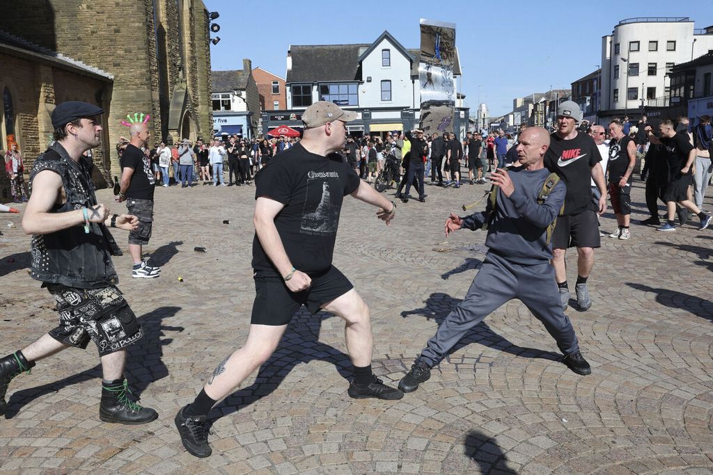 Pengunjuk rasa sayap kanan berhadapan dengan kelompok antifasis di Blackpool, Inggris, Sabtu (3/8/2024)