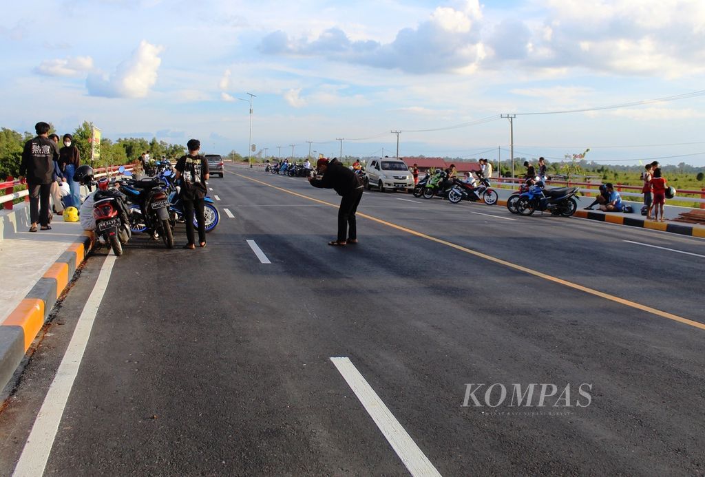 Warga dari beberapa daerah datang ke jalan baru atau <i>pile slab</i> di Bukit Rawi, Kabupaten Pulang Pisau, Kalimantan Tengah, Minggu (11/9/2022). Mereka bahkan nongkrong di pinggir jalan, tepatnya di ruas istirahat di jalan layang tersebut.