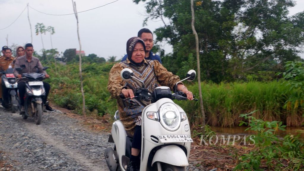 Menteri Sosial Tri Rismaharini mengendarai sepeda motor menuju rumah sejahtera terpadu (RST) di Desa Sungai Pitung, Kecamatan Alalak, Kabupaten Barito Kuala, Kalimantan Selatan, Selasa (11/6/2024) sore. 