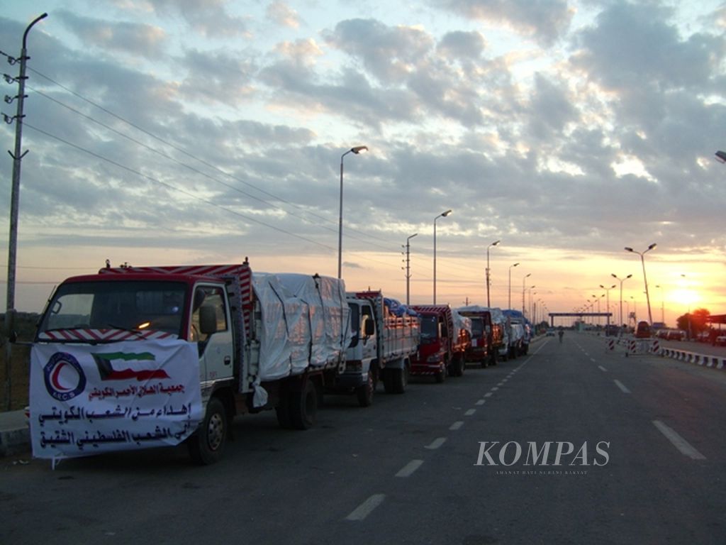 Sejumlah truk yang membawa bantuan kemanusiaan bagi warga Palestina di Jalur Gaza menunggu di dekat pintu gerbang Rafah, Mesir, Senin (12/1/2009), sebelum diizinkan masuk ke Jalur Gaza. Muatan truk ini nantinya harus dipindahkan ke truk Israel sebelum dibawa ke wilayah Jalur Gaza. 