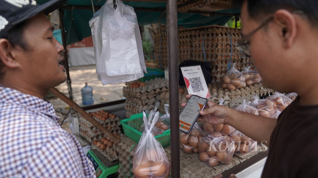 Warga membayar telur menggunakan sistem pembayaran pindai cepat kode unik (QRIS) di Jalan Bendungan Hilir, Jakarta Pusat, Senin (4/9/2023).
