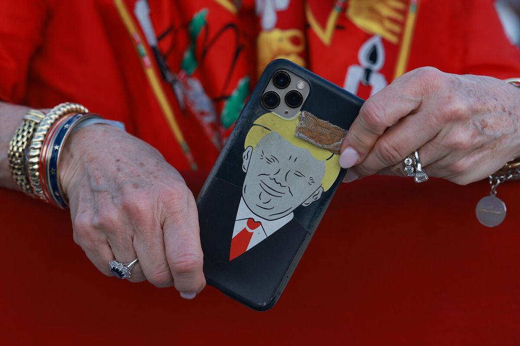 Pendukung Donald Trump membawa karikatur mantan Presiden Amerika Serikat itu dalam kampanye di Miami, Florida, AS, 6 November 2022. 