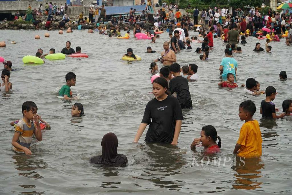 Wisatawan berekreasi di kawasan Pantai Indah Ancol, Taman Impian Jaya Ancol, Jakarta Utara, pada hari kedua Idul Fitri 1443 Hijriah, Selasa (3/5/2022). Pengelola menargetkan kunjungan rata-rata 55.000 orang per hari selama libur Lebaran pada 2-15 Mei 2022.