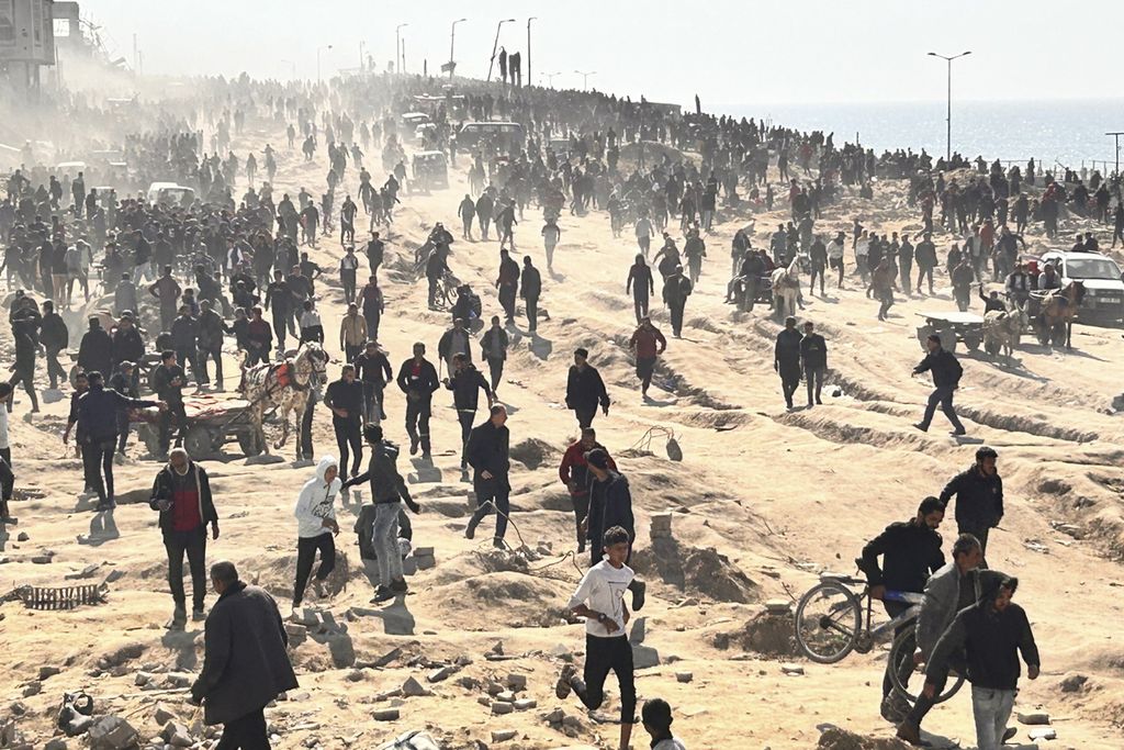 Warga Palestina berlarian untuk mendapatkan bantuan kemanusian yang dikirimkan melalui udara di Kota Gaza, Minggu (25/2/2024). 