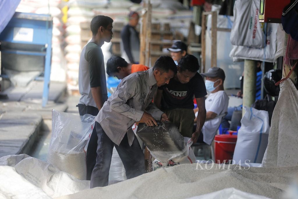 Buruh mengaduk beras di Pasar Induk Beras Cipinang, Jakarta, Senin (7/11/2022). 