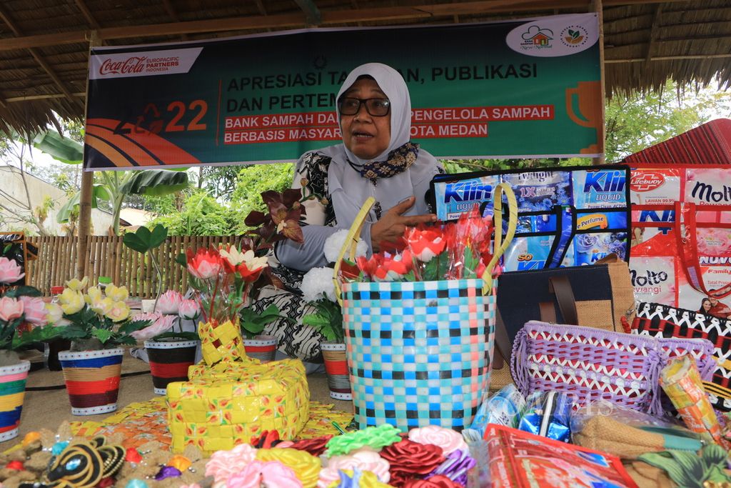 Ainun Saniah (65) menunjukkan sejumlah produk hasil kreasi daur ulang sampah plastik seperti tas, tikar, bunga tiruan, dan tempat tisu pada pertemuan bank sampah di Kota Medan, Sumatera Utara, Selasa (24/1/2023).