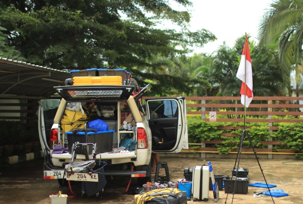 Mobil dan peralatan pesepeda asal Indonesia, Royke Lumowa, tengah dibongkar di Laos saat menyiapkan peralatan upacara HUT Kemerdekaan Indonesia.