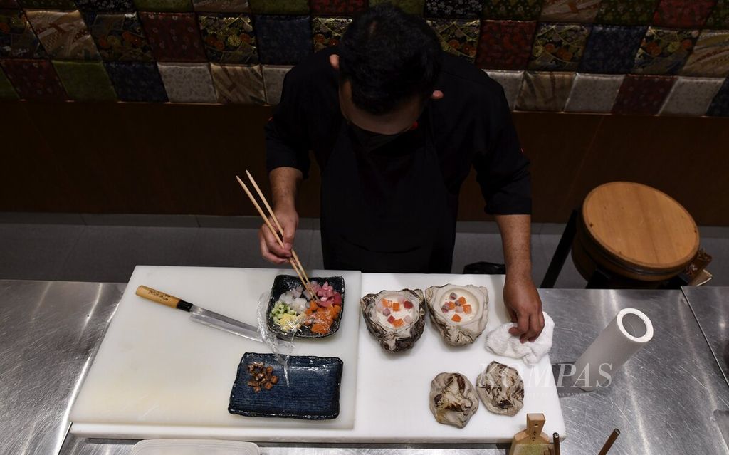 Chef menyiapkan menu Hamachi Kama Shioyaki di Sake+ Arcadia, Jakarta. 