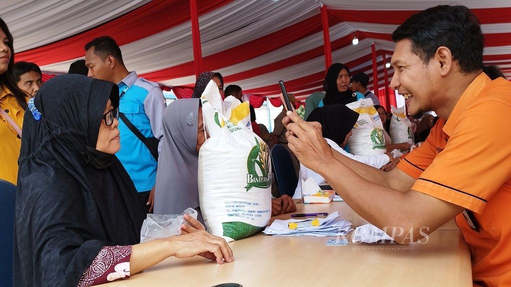 Masyarakat menerima bantuan beras cadangan pemerintah di Gudang Bulog DKI Jakarta dan Banten, Jakarta Utara, Senin (11/9/2023).