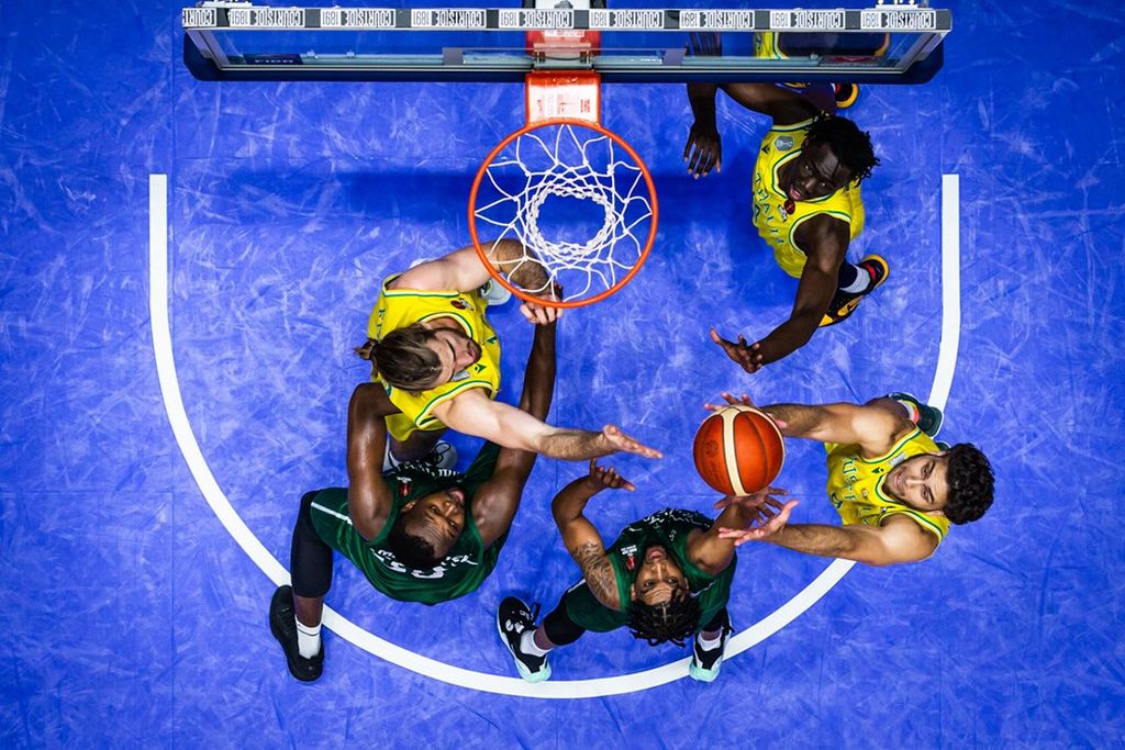 Perebutan <i>rebound</i> terjadi antara pemain Australia (berjersei kuning) dan Arab Saudi dalam laga lanjutan Grup A Piala Asia FIBA 2022 di Istora Senayan, Jakarta, Kamis (14/7/2022). Australia menyudahi laga dengan kemenangan 76-52.